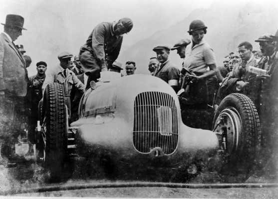 Bild (1/6): Mercedes Benz W 25 (1934) - Klausenrennen-Sieger Rudolf Caracciola mit Startnummer 65 und Streckenrekord (© Archiv Daimler AG, 1934)