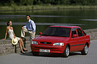 Bild (7/11): Ford Escort Ghia (1993) - Ein Escort mit Mann und Frau daneben (© Ford Archiv / Werk, 1993)